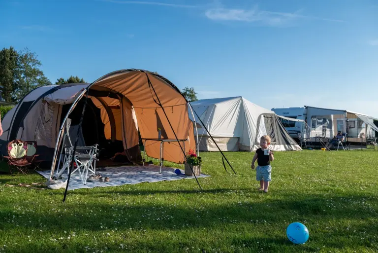Kind bij een tent op de kampeerplaatsen van Het Platte Putje