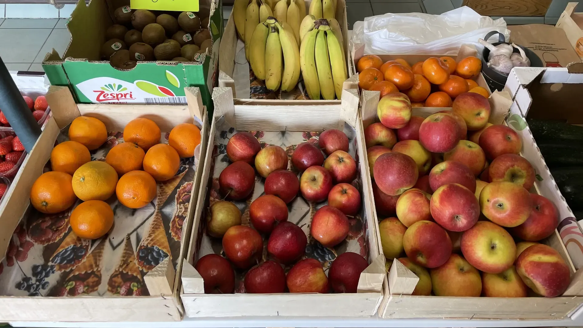 Kratten vers fruit — kiwi's, bananen, mandarijnen en appels — in verswinkel De Groe'ne Poort in Groede